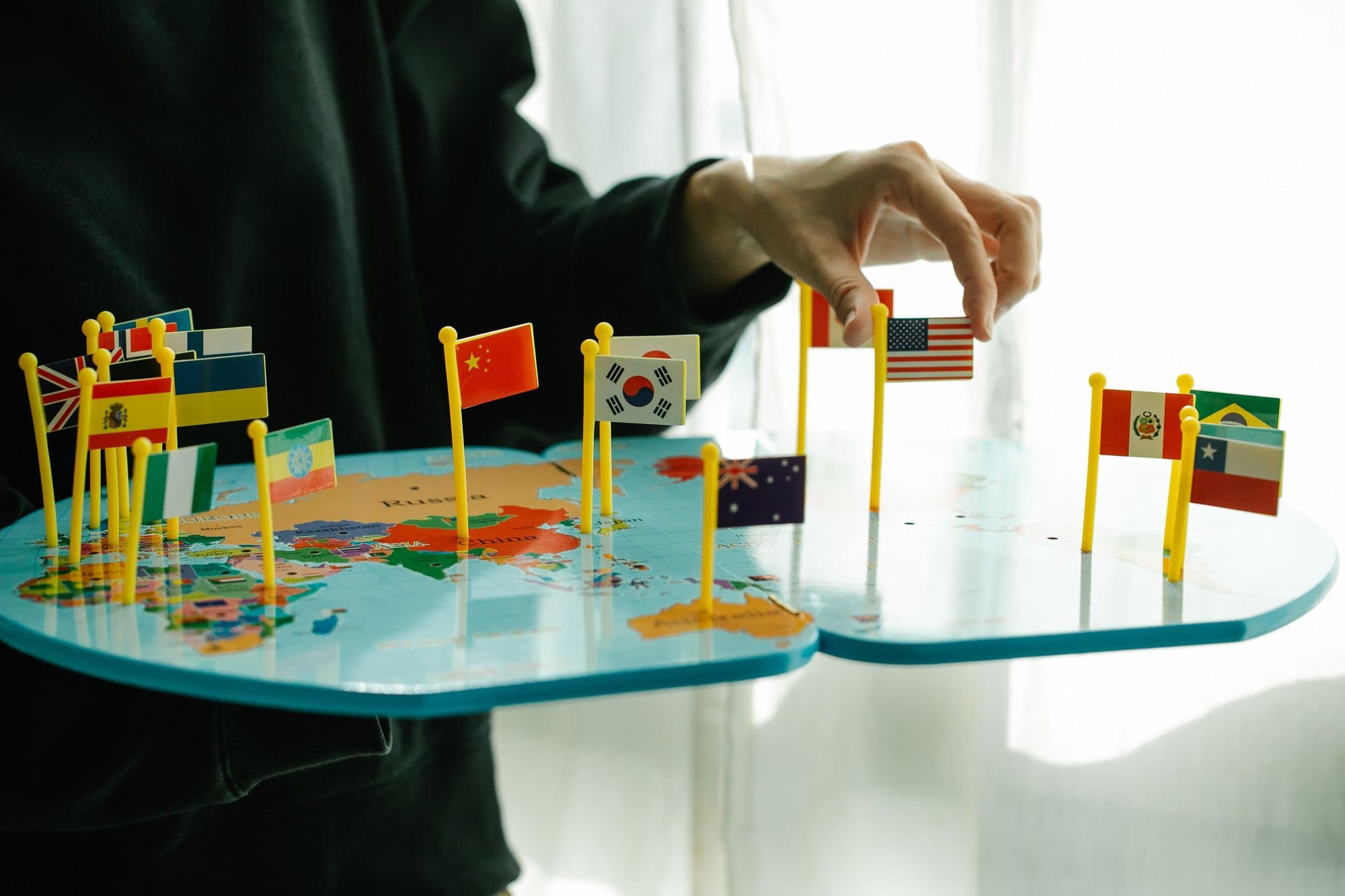 A world map marked with flags, representing The Mentor Tech's international delivery and recruiting network